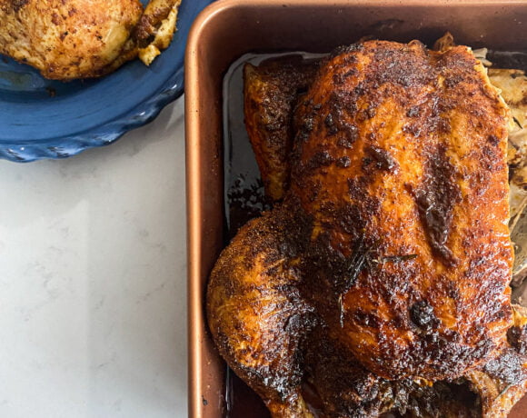 nigerian roasted chicken carved with a serving on a blue plate