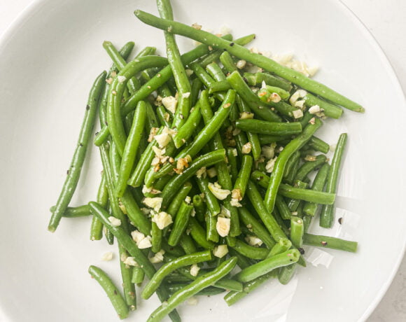 plated cooked green beans with chopped garlic